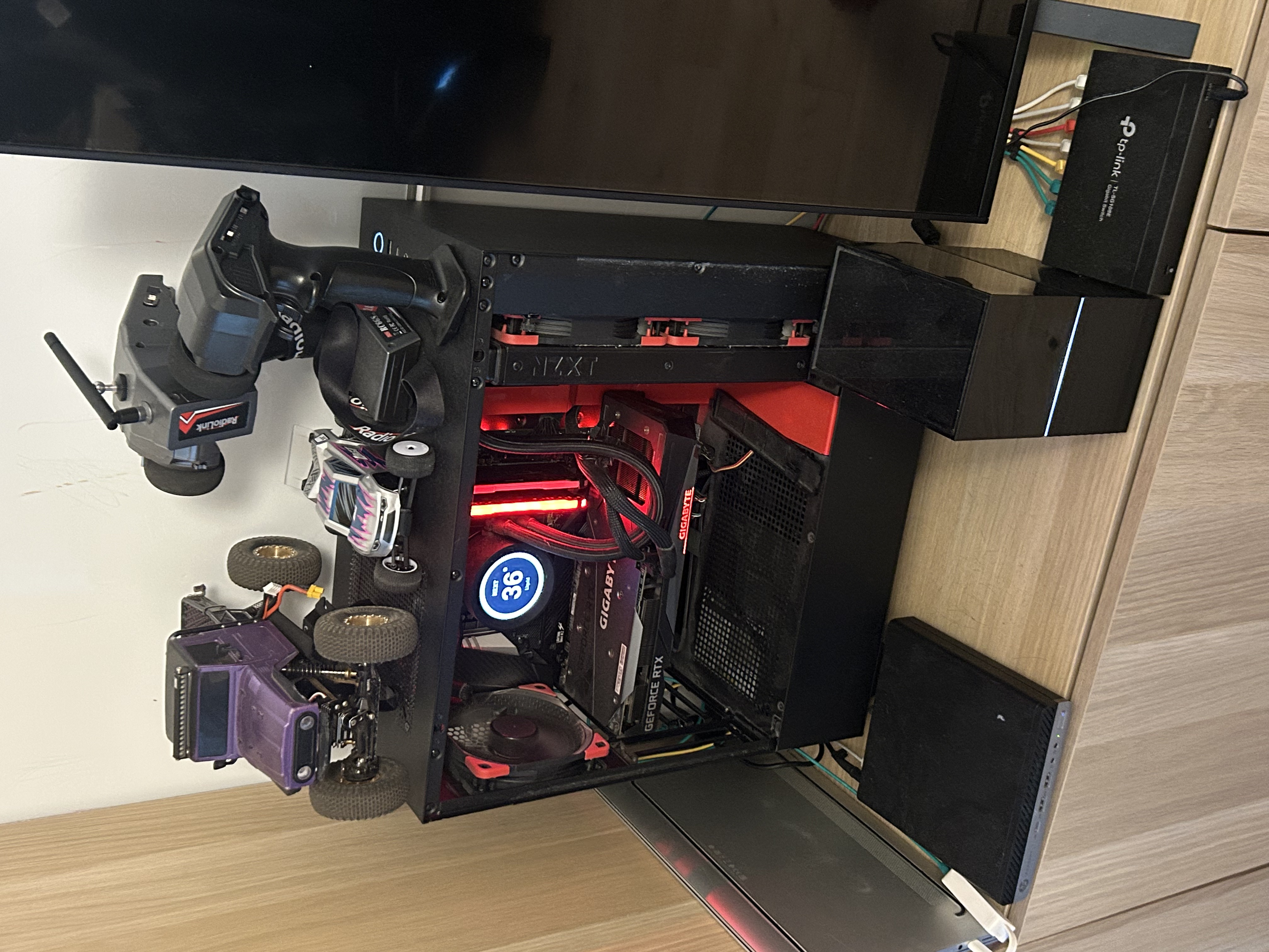 Homelab hardware setup with Proxmox servers, network switch, and RAID storage enclosure on desk.